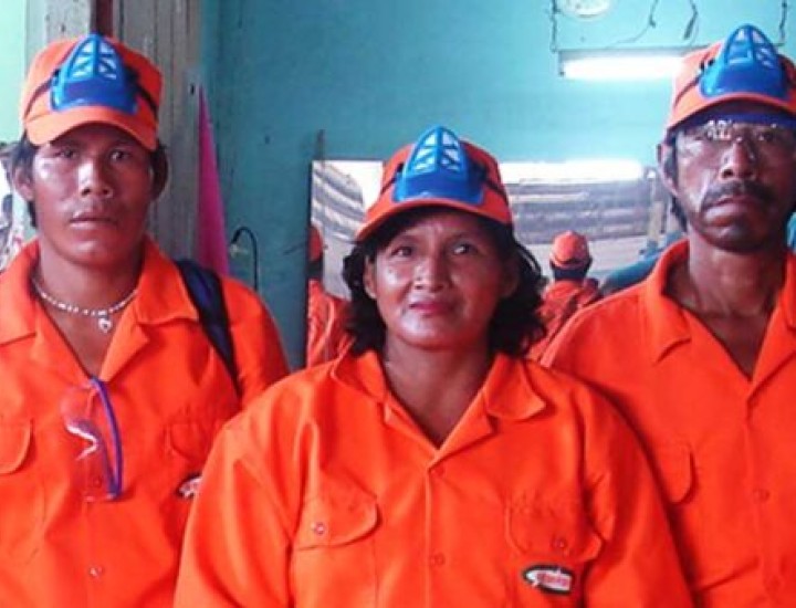 Three people pose in orange coverall suits