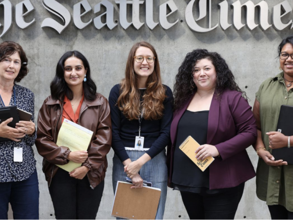 Reporters and editors stand in front of The Seattle Times