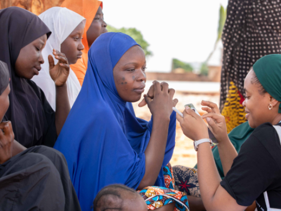 Women speak in a circle outside