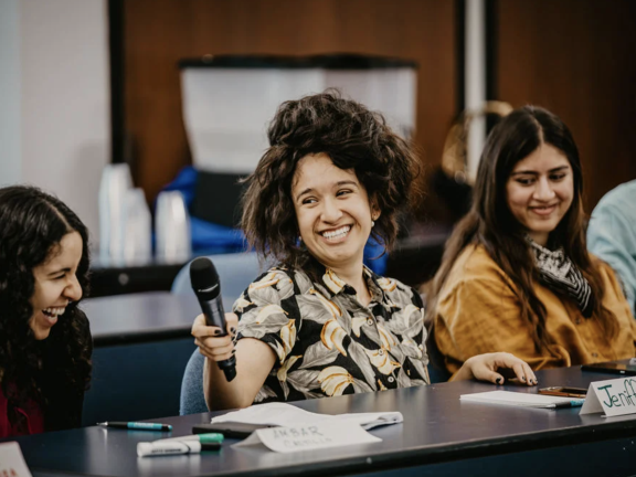 A woman with a microphone smiles