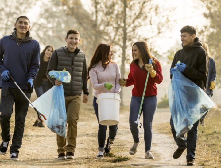 Young adults pick up trash in a park