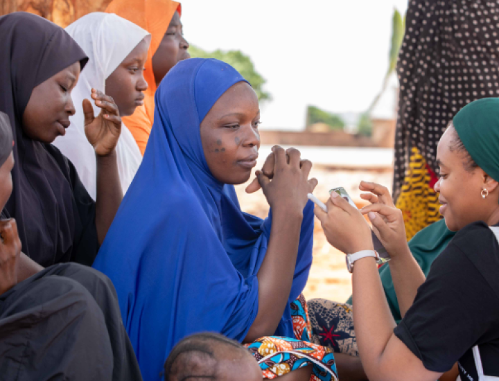 Women speak in a circle outside