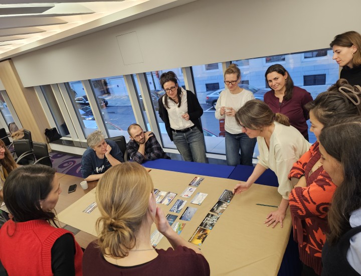 People participating in a workshop gather around a table to discuss